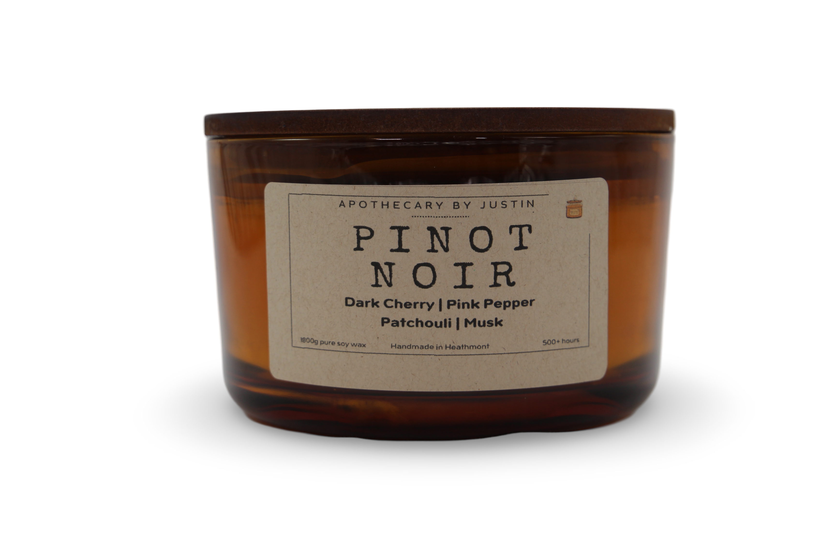Dark cherry fragrance candle in amber jar with notes of pink pepper and musk for a cozy ambiance