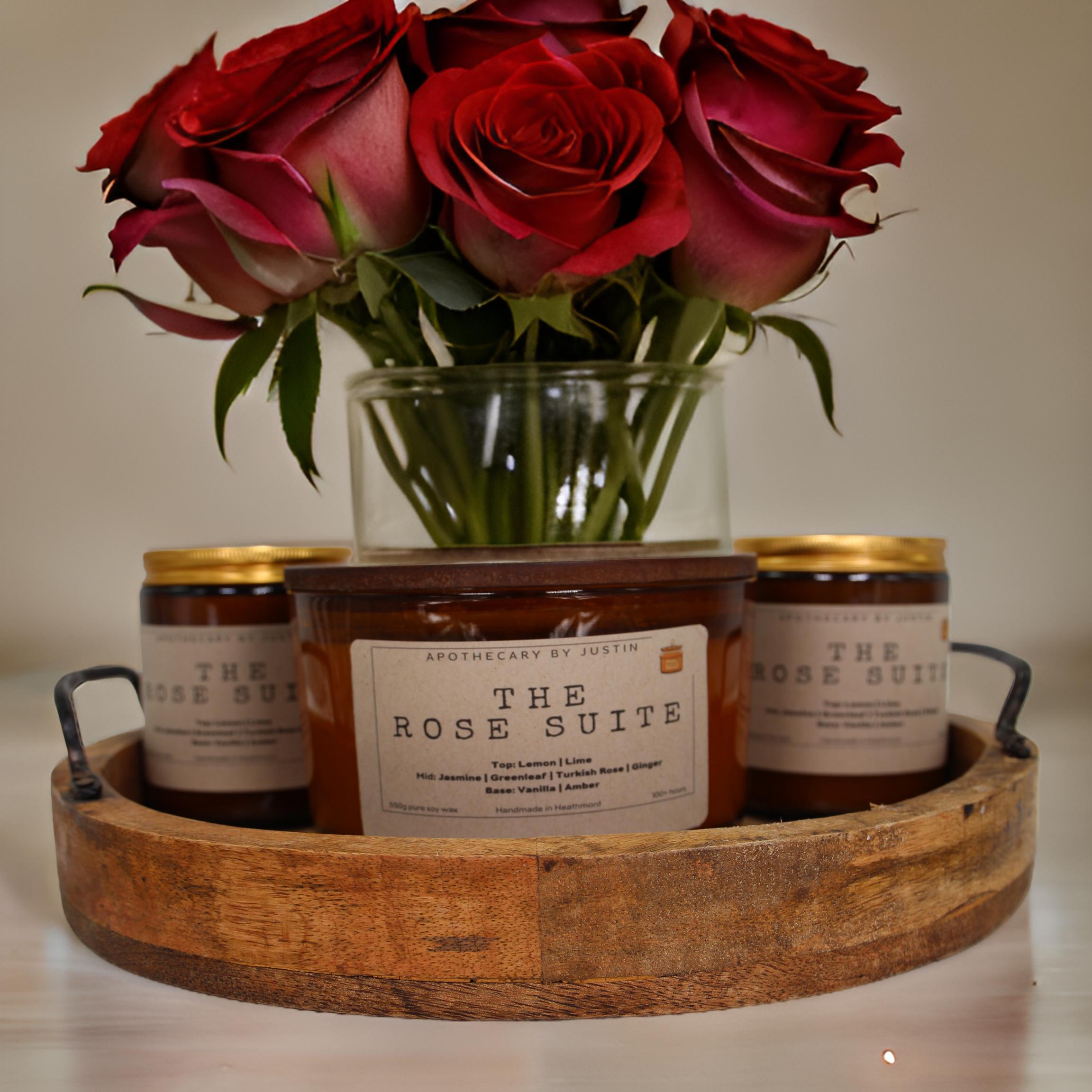 Strong hot-throw candles in a wooden tray with fresh roses for a cozy ambiance