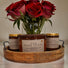 Strong hot-throw candles in a wooden tray with fresh roses for a cozy ambiance