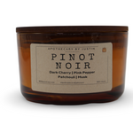 Dark cherry fragrance candle in amber jar with notes of pink pepper and musk for a cozy ambiance