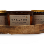 Hand-poured aroma candle set in a wooden tray featuring Tobacco scent with various notes