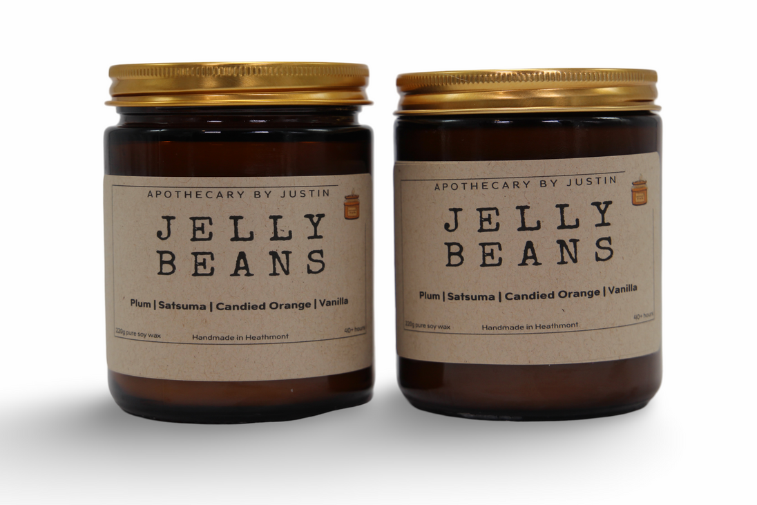 Two unique home fragrance candles in amber jars featuring Plum, Satsuma, and Candied Orange scents