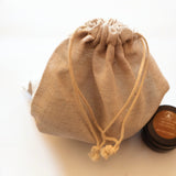 Calico drawstring bag with a sample candle beside it